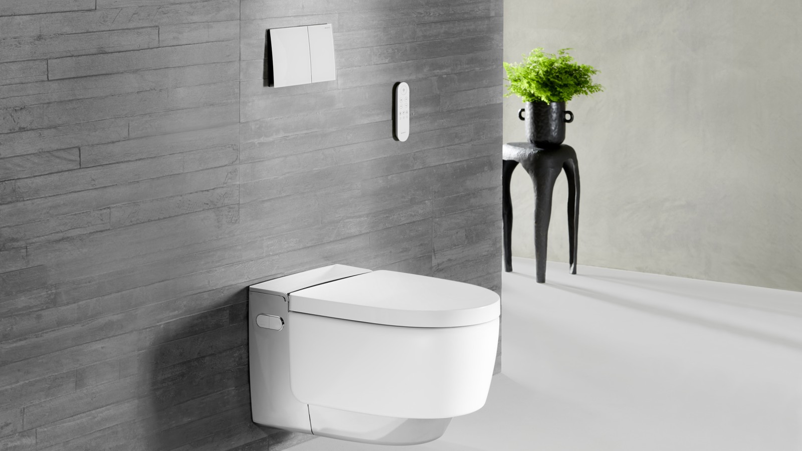 Geberit AquaClean Mera Dusch-WC an einer Schieferwand, mit Fernbedienung an der Wand