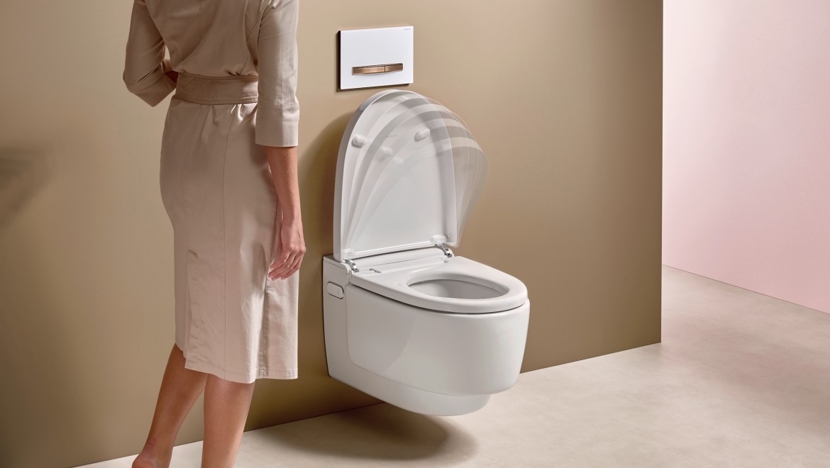 Person steht vor einem geöffneten Geberit AquaClean Dusch-WC im Badezimmer